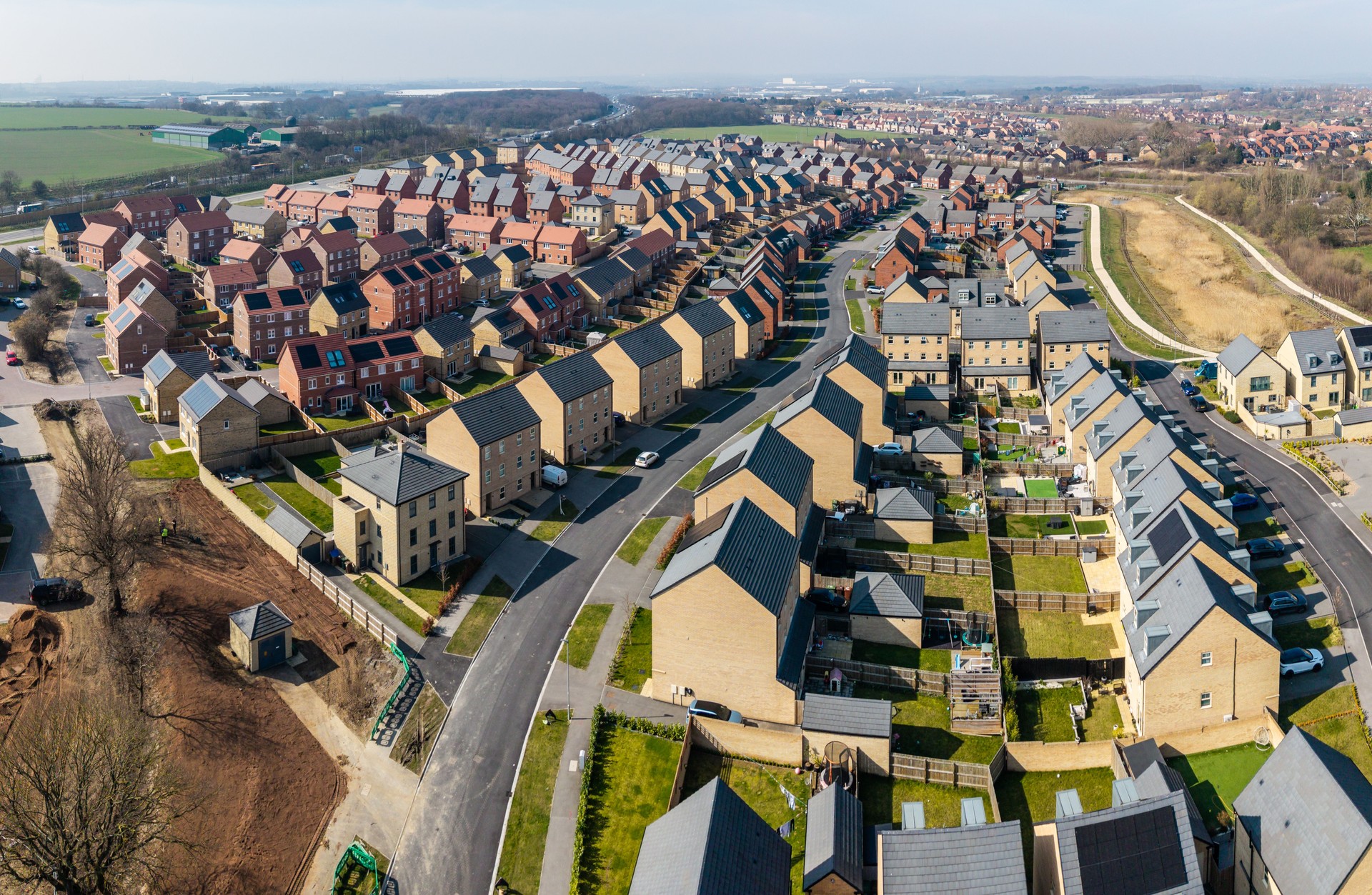 Aerial view of a new build housing estate with characterless houses in a row